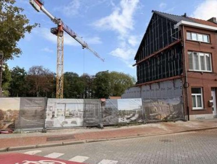 Straatzijdige werf met torenkraan en het bestaande gebouw